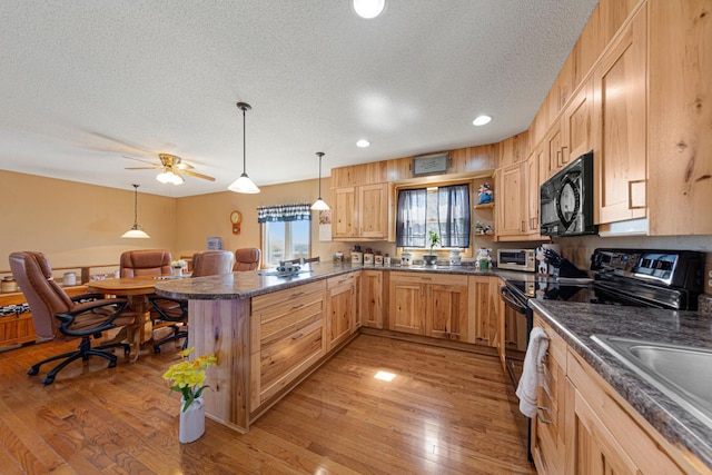 19023 Davis Ave, Faribault, MN 55021 - kitchen with black appliances, dark countertops, a peninsula, and a textured ceiling
