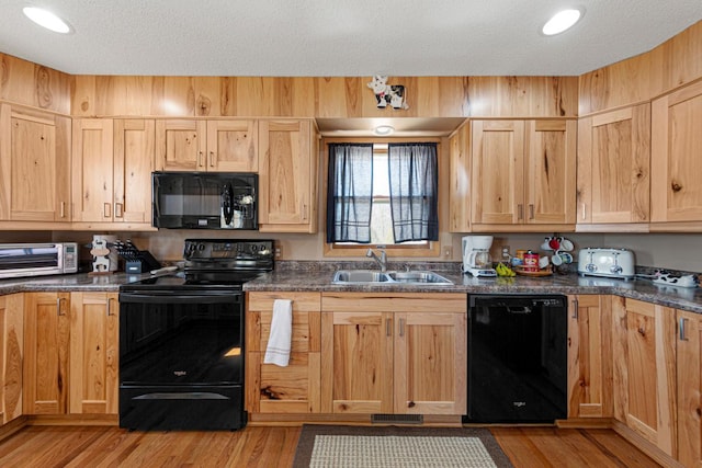 19023 Davis Ave, Faribault, MN 55021 - kitchen featuring light brown cabinetry, a toaster, a sink, black appliances, and dark countertops
