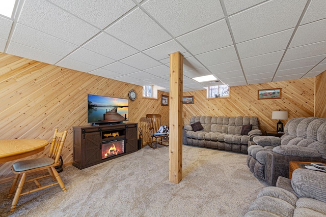 19023 Davis Ave, Faribault, MN 55021 - living area featuring a paneled ceiling, wood walls, a glass covered fireplace, and carpet floors