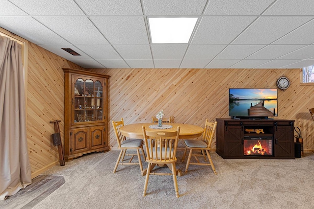 19023 Davis Ave, Faribault, MN 55021 - dining area with a drop ceiling, wood walls, visible vents, and carpet floors