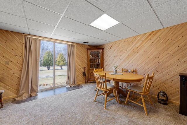19023 Davis Ave, Faribault, MN 55021 - carpeted dining room with wooden walls, baseboards, visible vents, and a paneled ceiling