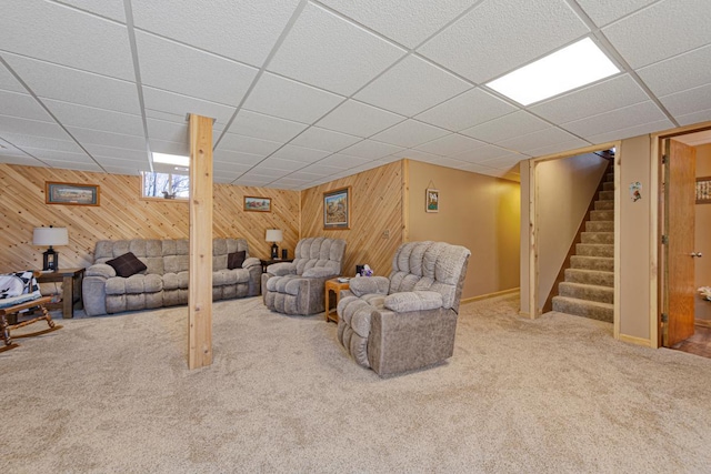 19023 Davis Ave, Faribault, MN 55021 - living room with a paneled ceiling, carpet floors, baseboards, wooden walls, and stairs