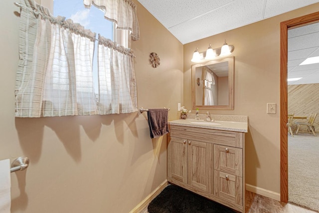 19023 Davis Ave, Faribault, MN 55021 - bathroom featuring baseboards, vanity, and vaulted ceiling