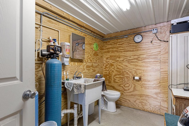 19023 Davis Ave, Faribault, MN 55021 - half bath featuring wooden walls, toilet, and concrete floors