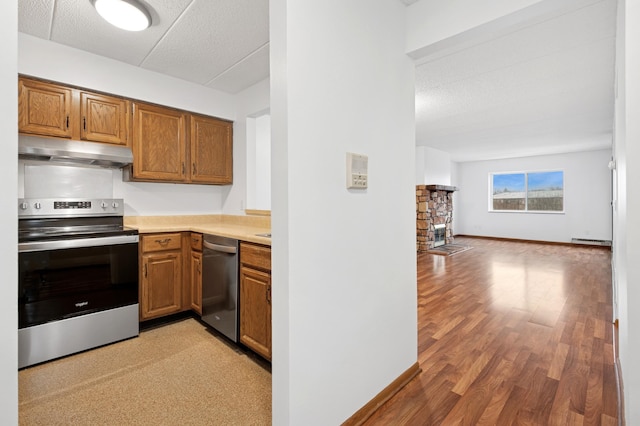 3300 Louisiana Ave S Unit 523, Saint Louis Park, MN 55426 - kitchen featuring stainless steel appliances, under cabinet range hood, brown cabinets, light countertops, and open floor plan