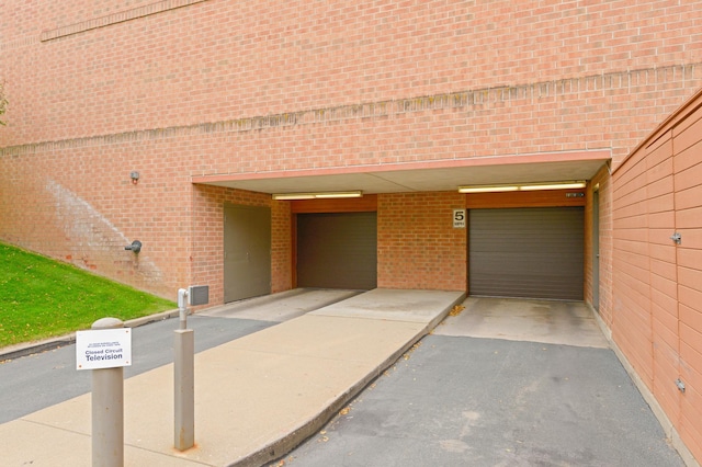 3300 Louisiana Ave S Unit 523, Saint Louis Park, MN 55426 - view of exterior entry with brick siding, a garage, a carport, and driveway