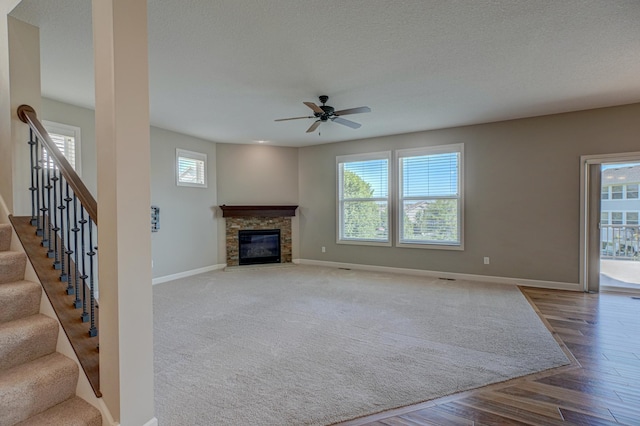 4764 Ashton Curv, Woodbury, MN 55129 - unfurnished living room featuring a ceiling fan, a fireplace, wood finished floors, and stairs