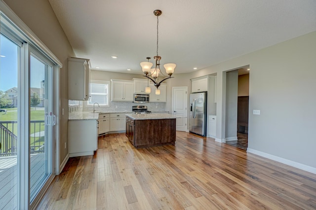 4764 Ashton Curv, Woodbury, MN 55129 - kitchen featuring appliances with stainless steel finishes, a chandelier, backsplash, light wood-type flooring, and recessed lighting