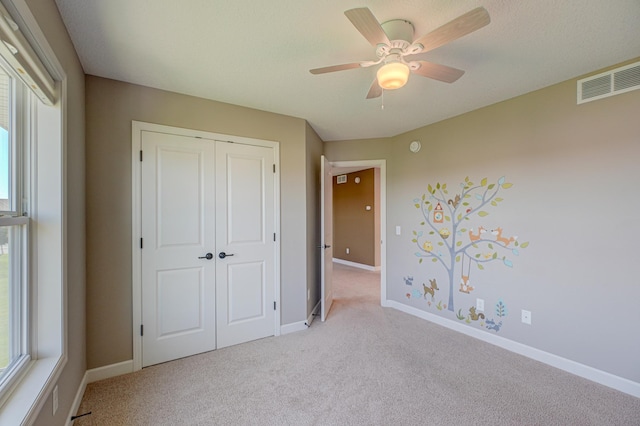 4764 Ashton Curv, Woodbury, MN 55129 - unfurnished bedroom featuring light colored carpet, a closet, multiple windows, and a ceiling fan