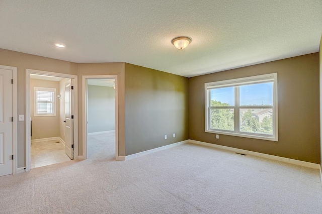 4764 Ashton Curv, Woodbury, MN 55129 - empty room featuring light colored carpet, a textured ceiling, and recessed lighting