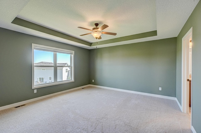 4764 Ashton Curv, Woodbury, MN 55129 - spare room featuring a tray ceiling, a textured ceiling, carpet flooring, and ceiling fan