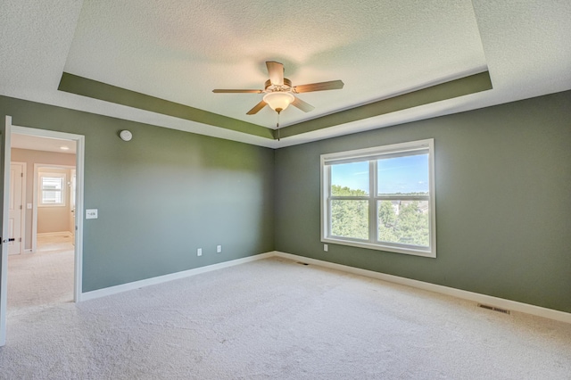 4764 Ashton Curv, Woodbury, MN 55129 - carpeted spare room with a textured ceiling, a tray ceiling, and ceiling fan
