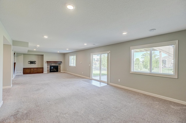 4764 Ashton Curv, Woodbury, MN 55129 - unfurnished living room with light colored carpet, recessed lighting, a glass covered fireplace, and a textured ceiling