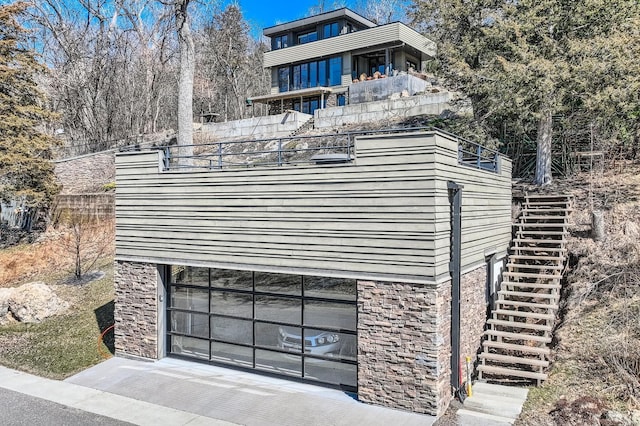 view of front of house featuring fence, stone siding, and stairs
