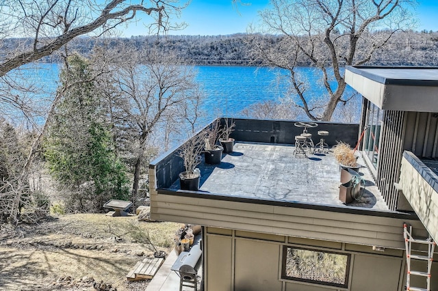 exterior space featuring a water view and a wooded view
