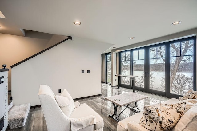 living room with light wood finished floors, a water view, and a wealth of natural light