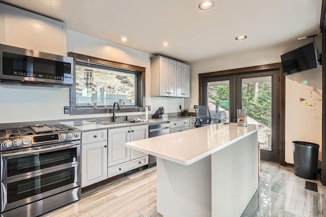 kitchen with light countertops, french doors, a sink, and stainless steel appliances