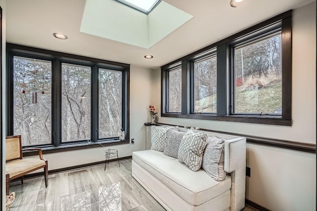 sitting room with a skylight, baseboards, plenty of natural light, and recessed lighting
