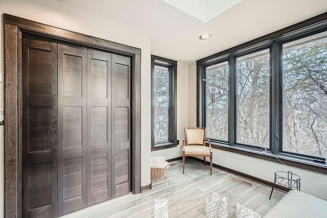 unfurnished room with light wood-style floors, visible vents, and baseboards