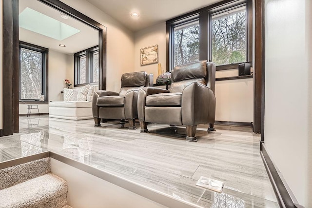 interior space with a skylight, baseboards, and recessed lighting