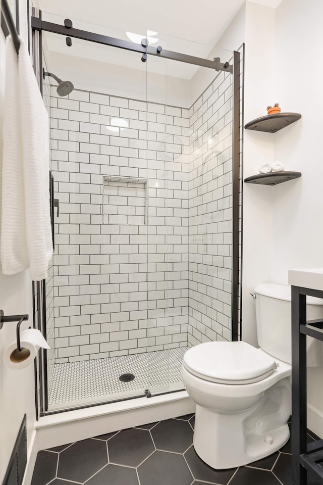 bathroom featuring tile patterned flooring, a stall shower, visible vents, and toilet