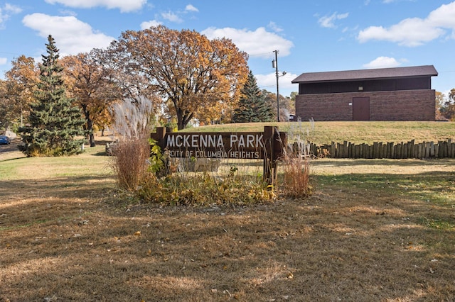 community sign featuring a lawn and fence