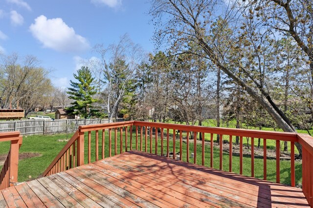 wooden terrace featuring a fenced backyard and a yard