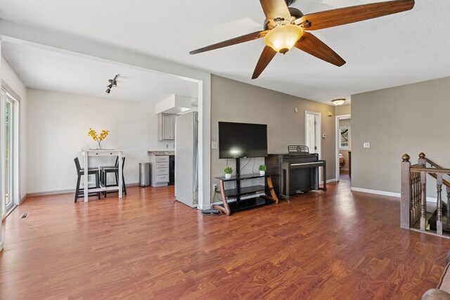 living room with baseboards, a ceiling fan, and wood finished floors