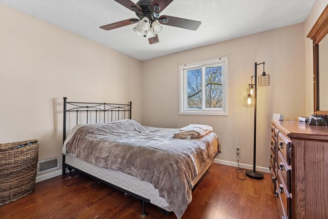 bedroom with visible vents, baseboards, ceiling fan, and wood finished floors