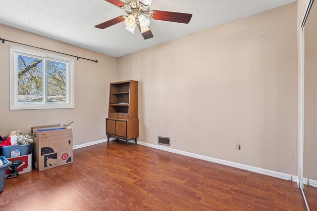 interior space featuring baseboards, ceiling fan, visible vents, and wood finished floors
