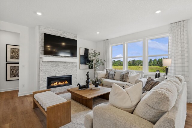 living room with baseboards, a fireplace, recessed lighting, and wood finished floors