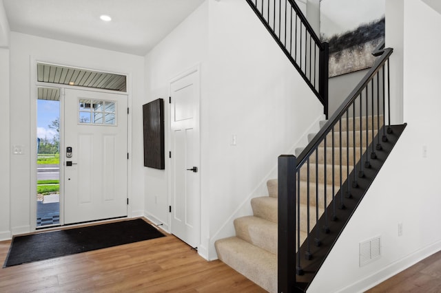 foyer with baseboards, visible vents, a healthy amount of sunlight, and wood finished floors