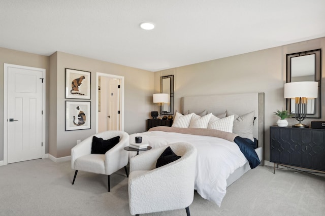 bedroom with baseboards and light colored carpet