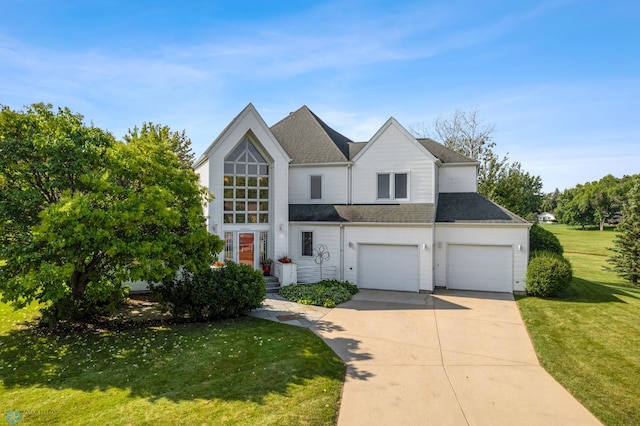 traditional-style home with a front yard, driveway, a garage, and roof with shingles