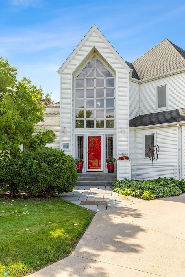 view of front of property with a front yard and roof with shingles