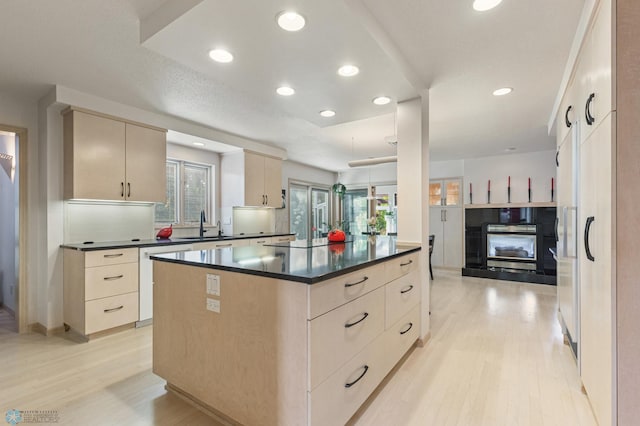 kitchen with plenty of natural light, dark countertops, light wood-type flooring, and dishwasher