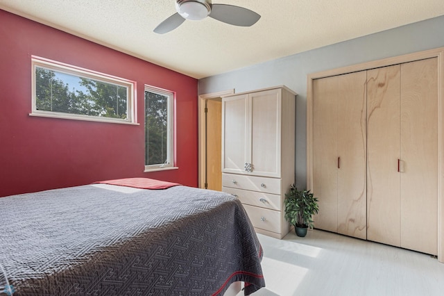 bedroom featuring a closet, a textured ceiling, and a ceiling fan
