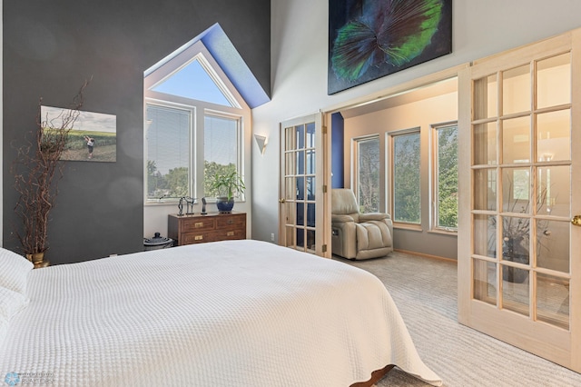 bedroom with french doors, a towering ceiling, and carpet flooring