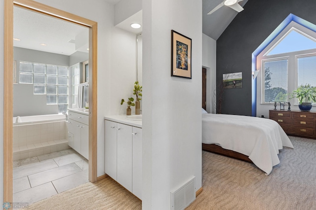 bedroom featuring ensuite bath, lofted ceiling, visible vents, and multiple windows