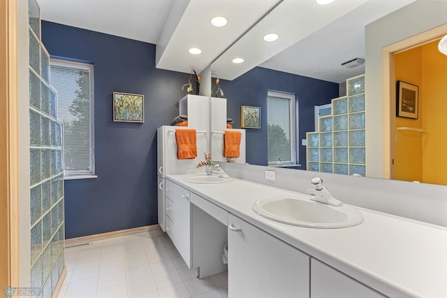 full bath with baseboards, double vanity, a sink, and recessed lighting