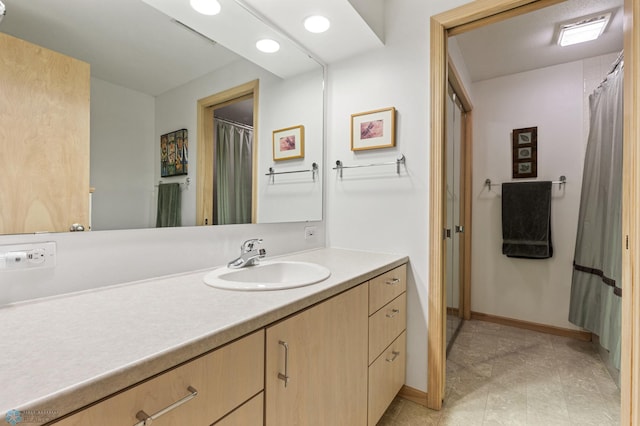 full bath featuring baseboards and vanity