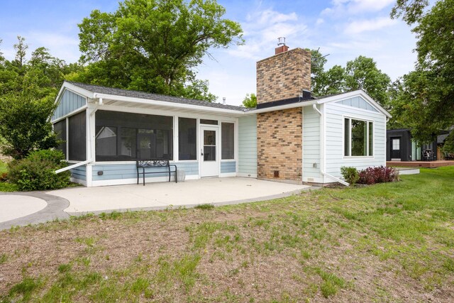 21370 654th Ave, Darwin, MN 55324 - rear view of property featuring a sunroom, a chimney, board and batten siding, a yard, and a patio