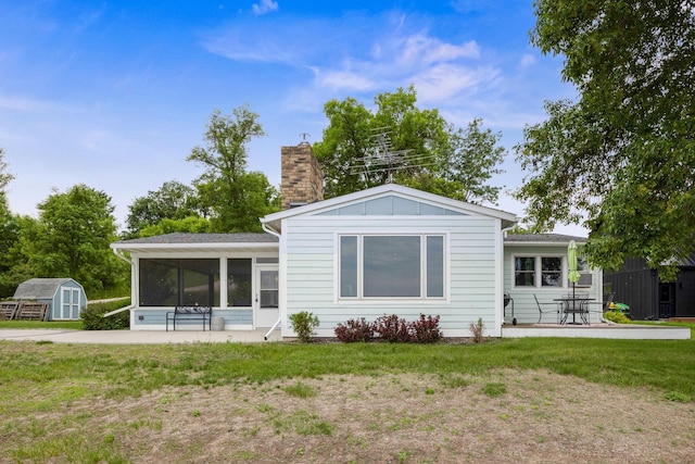 21370 654th Ave, Darwin, MN 55324 - back of property featuring a sunroom, a chimney, a yard, a patio, and board and batten siding