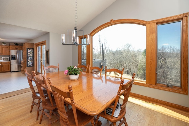 32337 Juniper Rd, Chatfield, MN 55923 - dining area with a chandelier, light wood-style floors, vaulted ceiling, and baseboards