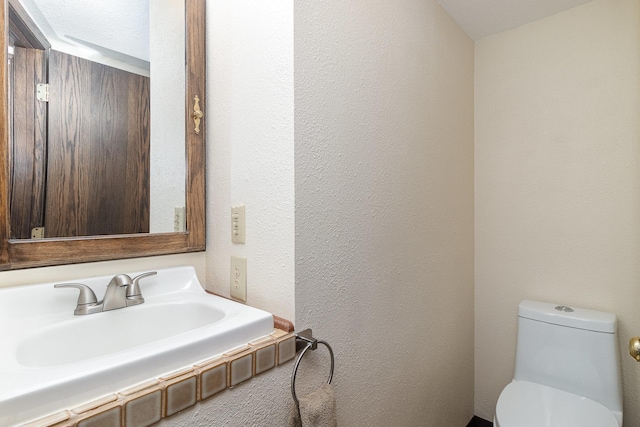 6200 37th St W, Webster, MN 55088 - bathroom featuring a sink, toilet, and a textured wall