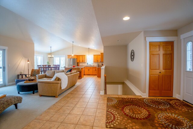 122 Ridge Rd, New London, MN 56273 - living area featuring lofted ceiling, light tile patterned floors, baseboards, a chandelier, and light carpet