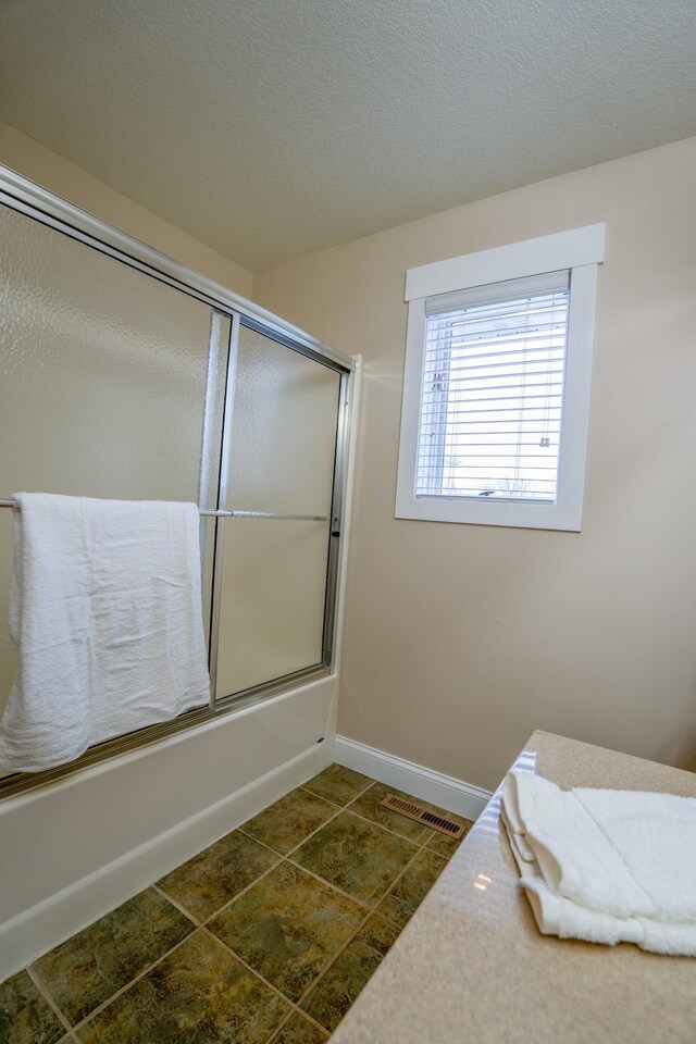 122 Ridge Rd, New London, MN 56273 - bathroom featuring bath / shower combo with glass door, vanity, and baseboards