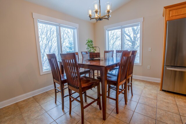 122 Ridge Rd, New London, MN 56273 - dining space with a chandelier, baseboards, lofted ceiling, and light tile patterned floors