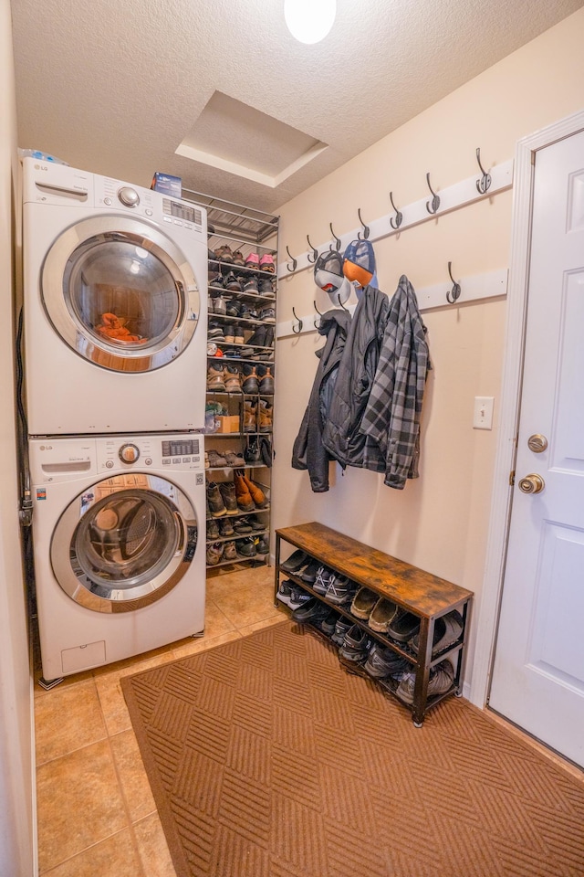 122 Ridge Rd, New London, MN 56273 - laundry area with stacked washer and clothes dryer, light tile patterned floors, and a textured ceiling