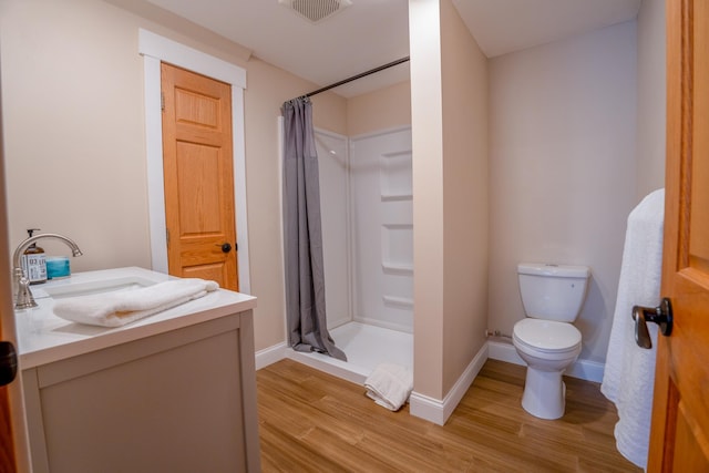 122 Ridge Rd, New London, MN 56273 - full bath featuring wood finished floors, a stall shower, toilet, vanity, and baseboards